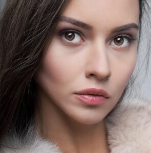 inner beauty and wellness Close-up portrait of a young woman with soft lighting and neutral tones.