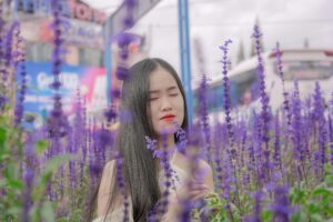 inner beauty and wellness A young woman stands peacefully with eyes closed, surrounded by flourishing purple lavender flowers.