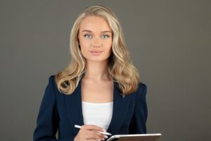 why some people look more attractive even without makeup Confident businesswoman in blue suit holding tablet, depicting leadership and technology.