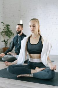 inner beauty and wellness Two adults meditating in a tranquil indoor setting, promoting wellness and focus.